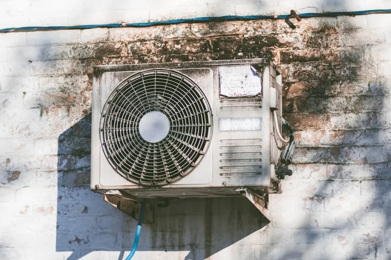 Unit outdoor AC kotor dan berkarat yang menunjukkan tanda perlu diperbaiki